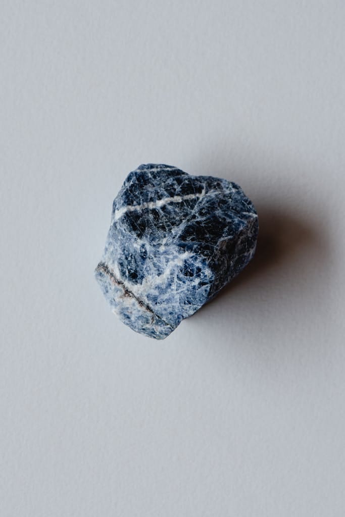 Detailed close-up of a sodalite rock, showcasing natural texture on a neutral backdrop.