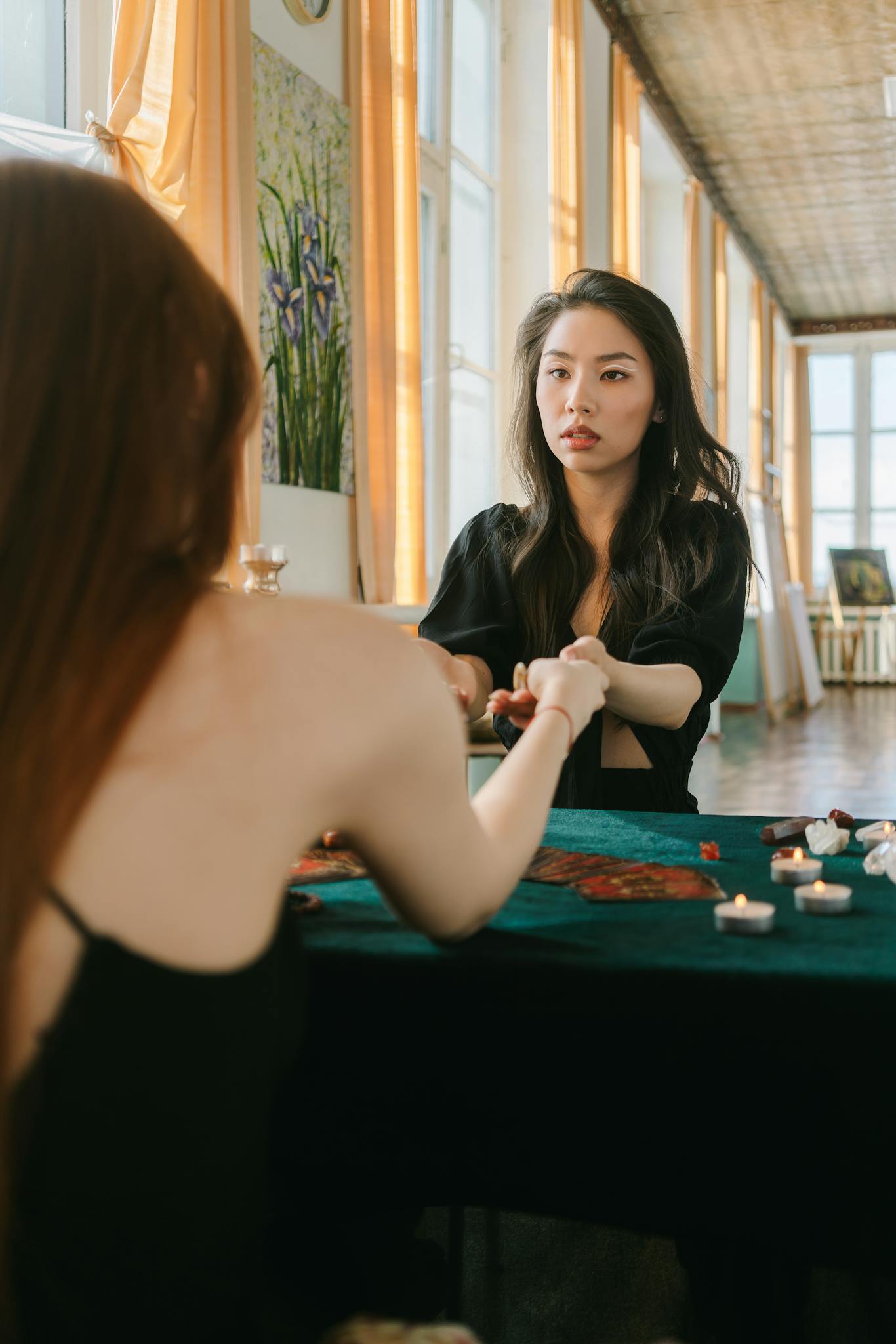 Two women having a tarot reading session in a serene indoor setting.